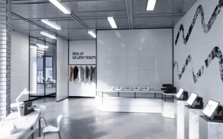 Wnętrze biura z minimalistycznym designem, białymi meblami i nowoczesnym oświetleniem.