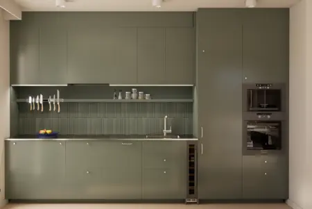 Kuchnia w stylu dopamine decor i japandi z zielonymi meblami i minimalistycznym wykończeniem.