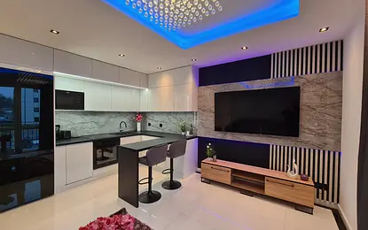 Nowoczesna kuchnia z białymi meblami i czarnymi detalami, z eleganckim blatem.