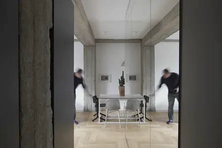 Wnętrze jadalni w stylu eklektycznym i minimalistycznym z białym stołem i czarnymi krzesłami.