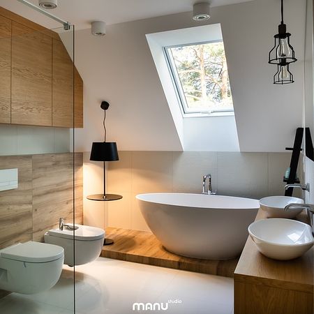 Wnętrze nowoczesnej łazienki z wanną, drewnem i minimalistycznymi detalami.
