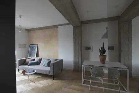 Eklektyczne wnętrze salonu z minimalistycznym stołem i nowoczesną sofą.
