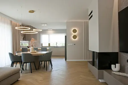 Jadalnia z okrągłym stolikiem, szarymi krzesłami, minimalistyczny styl, nowoczesny design.