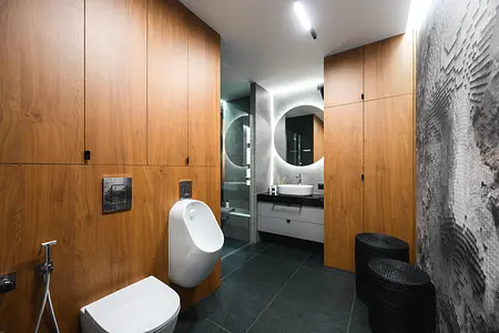 Wnętrze łazienki z drewnianymi meblami, nowoczesnymi detalami i industrialnym wykończeniem.
