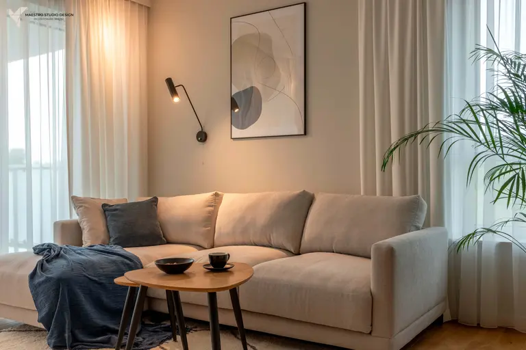 Wnętrze salonu w stylu boho z beżową sofą i rośliną