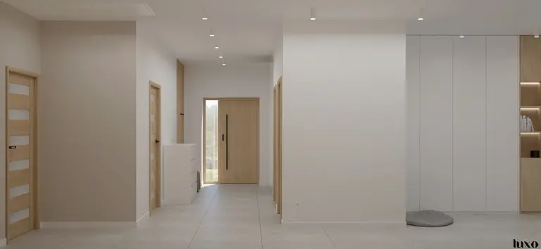 Przedpokój w stylu japandi i minimalistycznym z białymi ścianami i drewnianymi akcentami.