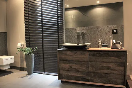 Nowoczesna łazienka z drewnianą szafką, minimalistycznymi akcentami i elegancką umywalką.