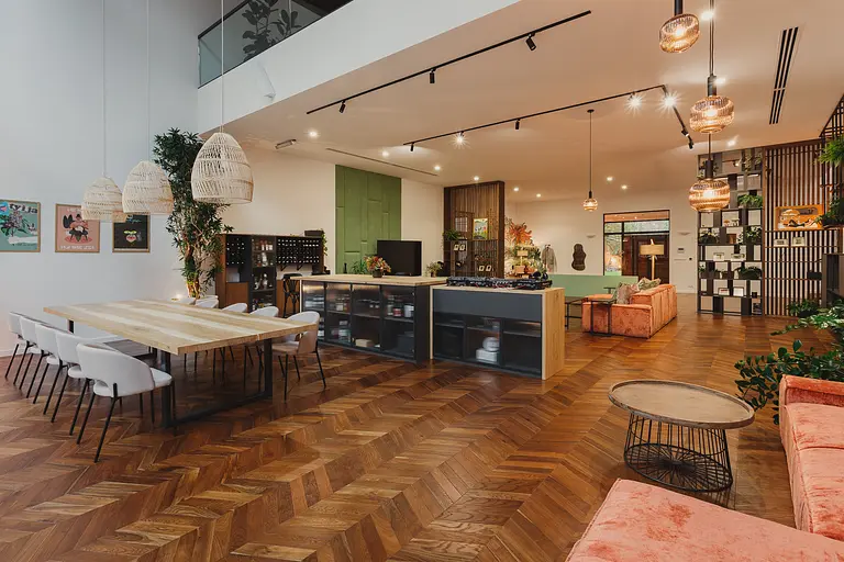 Wnętrze z drewnianym stołem, różowymi sofami i roślinami w stylu dopamine decor, eklektycznym, industrialnym, rustykalnym, vintage.