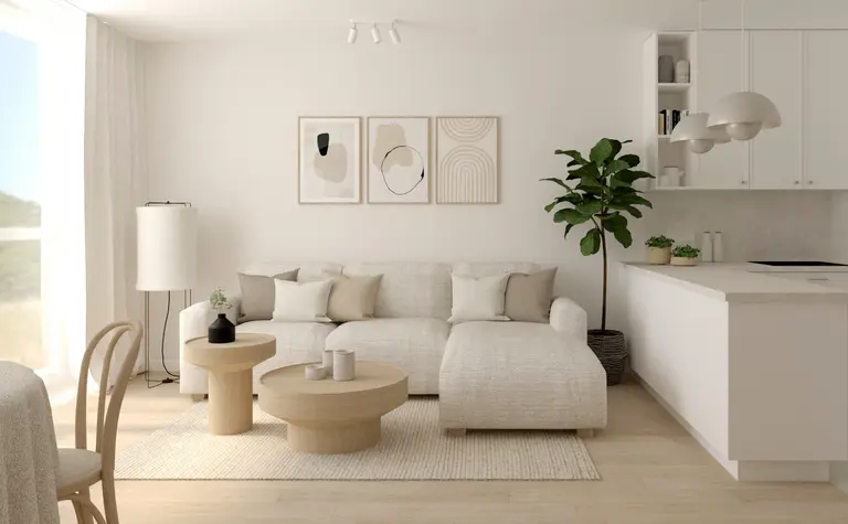 Wnętrze salonu z jasną sofą, drewnianymi stolikami i rośliną w stylu soft minimalizm.