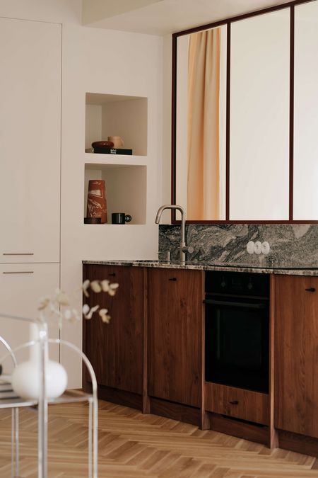 Kuchnia w stylu quiet luxury z drewnianymi meblami, minimalistycznym designem i vintage akcentami.