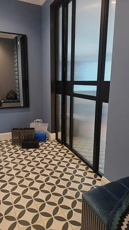 Przedpokój z niebieskimi ścianami, lustrzanym odbiciem i elegancką podłogą w stylu glamour.