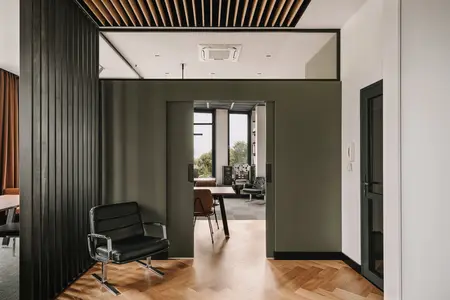Wnętrze z industrialnym i nowoczesnym stylem, czarny fotel, drewniana podłoga.