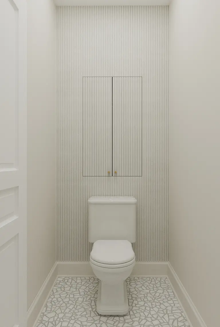 Toaleta w stylu art deco z białą ceramiką i mozaiką.