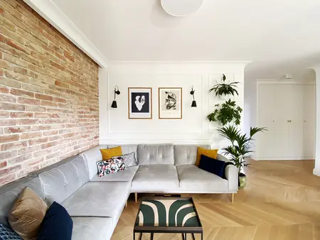 Wnętrze salonu minimalistycznego z ceglaną ścianą i roślinami, nowoczesny wystrój.