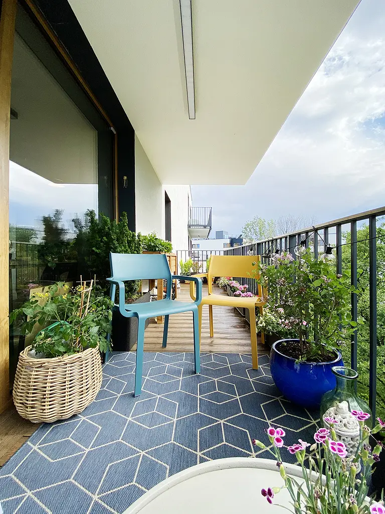 Balkon z minimalistycznymi meblami i zielenią, nowoczesny styl dekoracji.