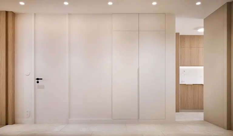 Wnętrze przedpokoju w stylu japandi, minimalistycznym i nowoczesnym z białymi i drewnianymi elementami.