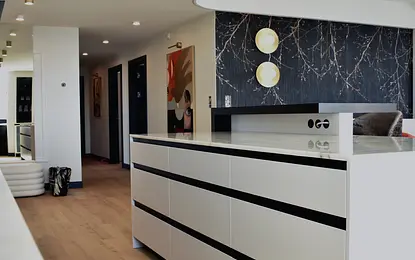 Eklektyczne wnętrze z białą komodą, czarnymi detalami i nowoczesnym oświetleniem.