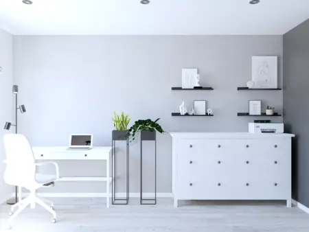 Wnętrze gabinetu w stylu industrialnym i minimalistycznym z białym biurkiem.