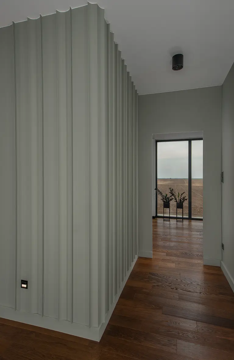 Korytarz w stylu minimalistycznym z zielonymi ścianami i drewnianą podłogą, nowoczesny design.