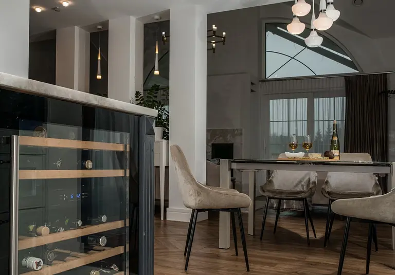 Wnętrze jadalni z nowoczesnym stołem i tradycyjnymi krzesłami w stylu quiet luxury.