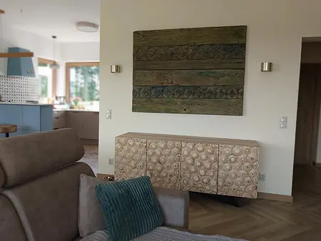 Wnętrze eklektycznego salonu z drewnianymi meblami i nowoczesnymi akcentami.