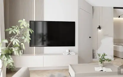 Wnętrze salonu z telewizorem, białymi meblami i zielonymi roślinami, styl glamour i nowoczesny.
