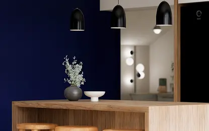 Wnętrze kuchni z drewnianym blatem, czarnymi lampami i niebieską ścianą, styl dopamine decor.