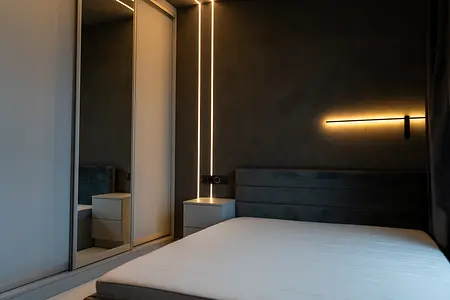 Wnętrze sypialni z nowoczesnym oświetleniem LED i lustrem