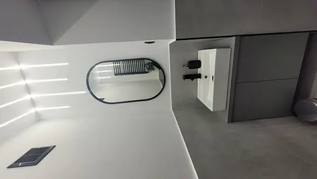 Nowoczesna łazienka z białą umywalką i szarymi płytkami w stylu minimalistycznym.