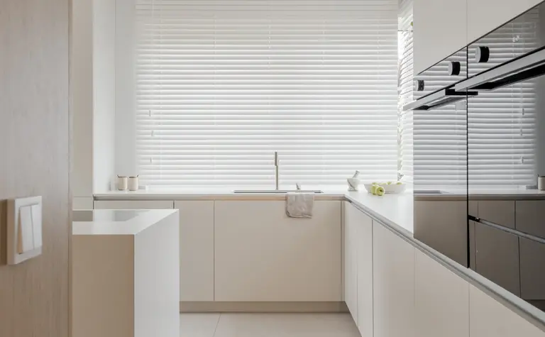 Nowoczesna kuchnia w stylu japandi, minimalistycznym, z jasnymi meblami i dużymi oknami.