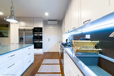 Kuchnia z białymi meblami, drewnianymi detalami, nowoczesny, quiet luxury, tradycyjny, współczesny.