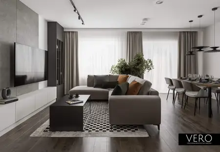 Wnętrze nowoczesnego salonu z minimalistycznym designem, szarymi meblami i zielonymi roślinami.
