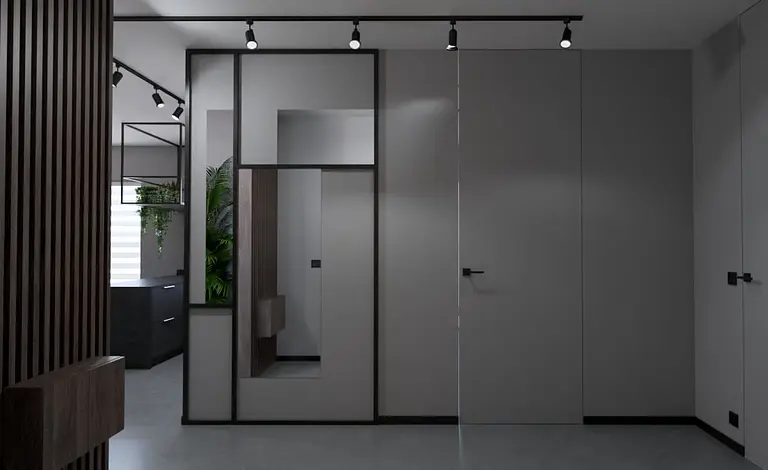 Przedpokój w stylu industrialnym i minimalistycznym z szarymi ścianami i nowoczesnymi detalami.