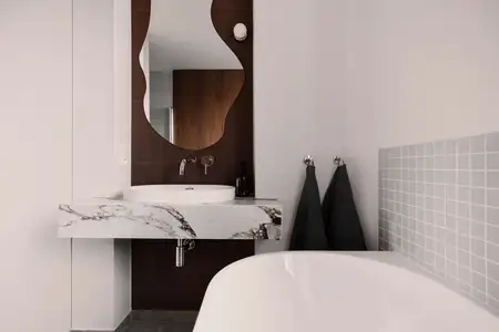 Nowoczesna łazienka z marmurową umywalką, lustrem i szarymi płytkami. Quiet luxury, soft minimalizm, vintage.