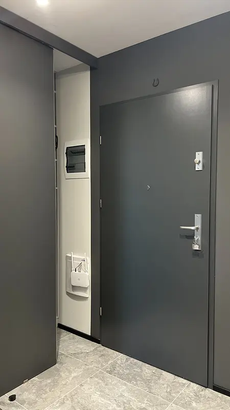 Nowoczesny przedpokój w soft minimalizmie z szarymi ścianami i współczesnymi detalami.