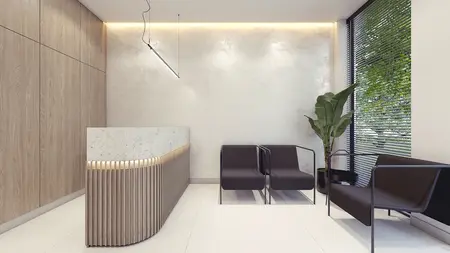 Wnętrze minimalistycznej recepcji z drewnianą ladą i nowoczesnymi fotelami.