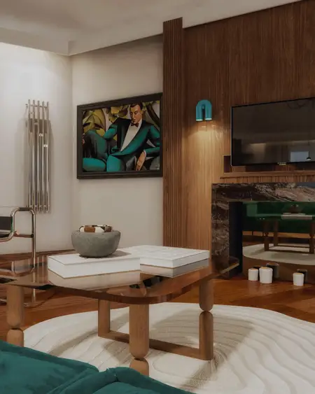 Wnętrze salonu w stylu art deco z zieloną sofą i drewnianymi detalami.