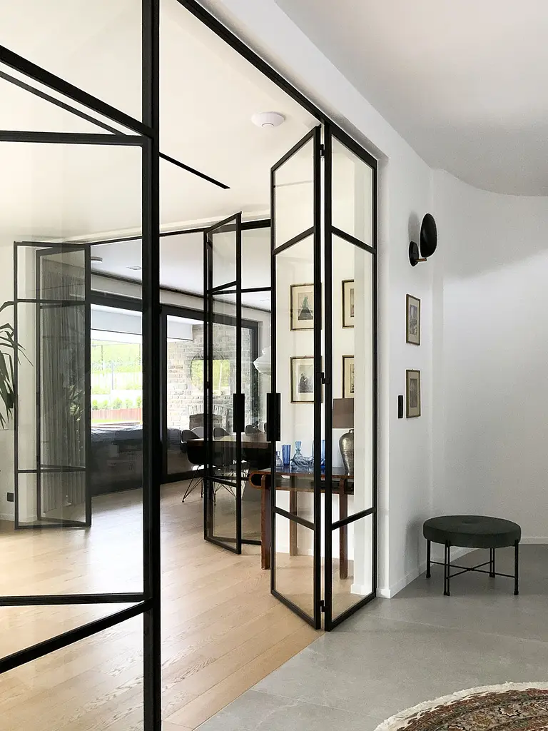 Wnętrze z przeszklonymi drzwiami, minimalistyczne wykończenie, styl minimaluxe, quiet luxury.