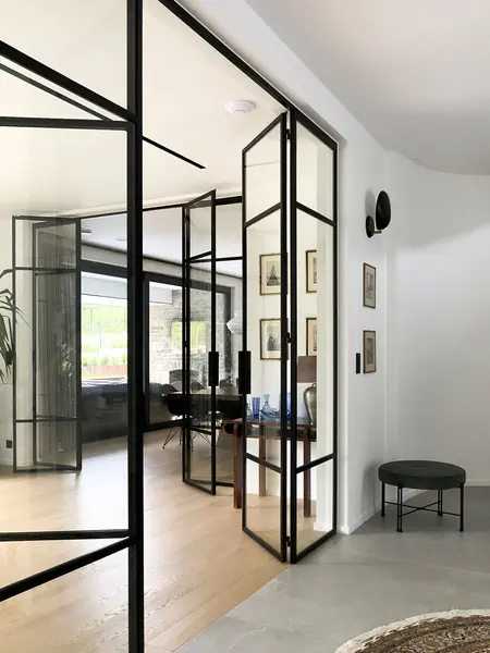 Wnętrze z przeszklonymi drzwiami, minimalistyczne wykończenie, styl minimaluxe, quiet luxury.