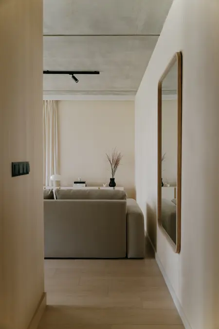 Wnętrze salonu w stylu industrialnym, japandi i skandynawskim z beżową sofą.
