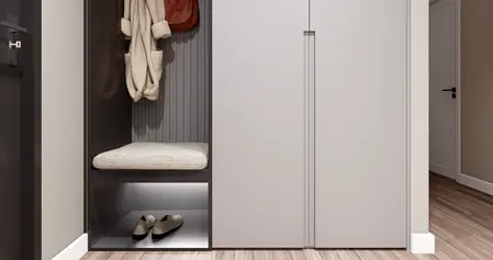Przedpokój z minimalistycznym designem, w stylu minimaluxe, z szarymi meblami i drewnianą podłogą.