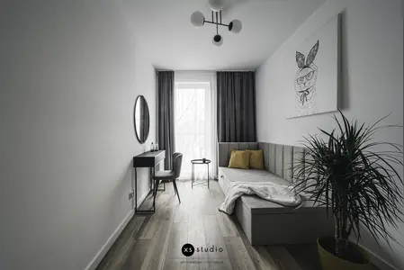 Wnętrze pokoju w stylu japandi z minimalistycznym narożnikiem i rośliną.