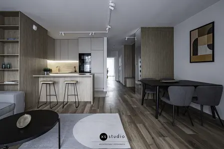 Wnętrze kuchni w stylu japandi z drewnianymi meblami i minimalistycznym oświetleniem.