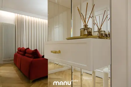 Nowoczesny salon z czerwonymi meblami, białą komodą i dekoracjami.