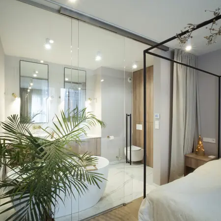 Wnętrze łazienki z białą wanną i drewnianymi detalami, styl quiet luxury.