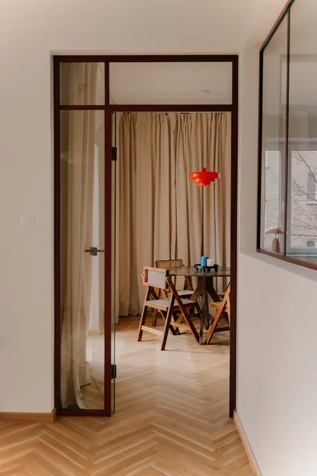 Wnętrze jadalni w stylu quiet luxury z drewnianym stołem i vintage lampą.