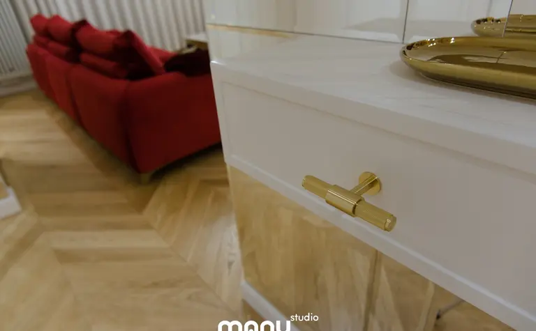 Nowoczesny salon z czerwonymi sofami i złotymi akcentami, tradycyjny design.