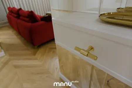 Nowoczesny salon z czerwonymi sofami i złotymi akcentami, tradycyjny design.