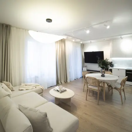 Wnętrze salonu z jasnymi zasłonami i drewnianym stołem, styl quiet luxury.