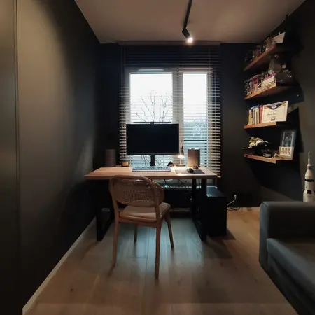 Wnętrze gabinetu z biurkiem, komputerem i minimalistycznymi akcentami w stylu quiet luxury.